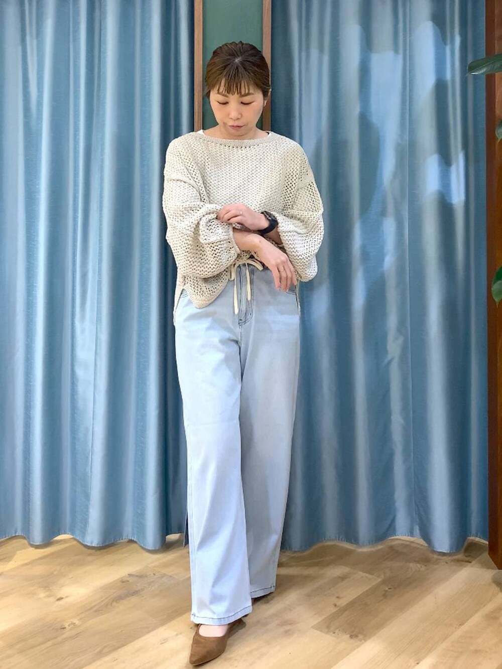 ベージュ系のニット/セーター、ブラウン系のトートバッグ、ホワイト系のTシャツ/カットソーを着用したレディースの冬コーディネートの5枚目の写真