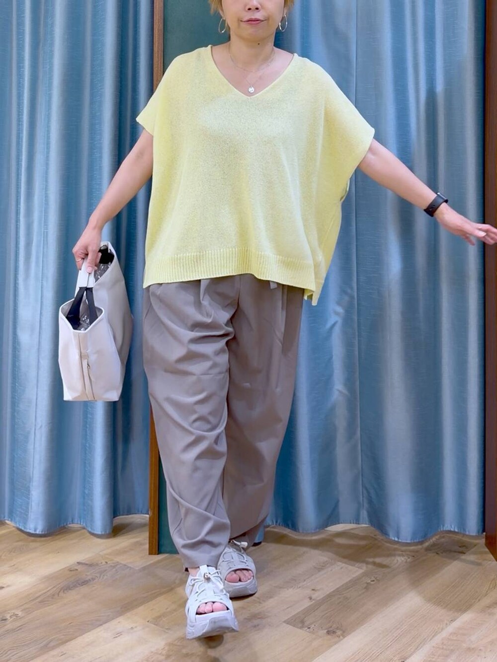 ホワイト系のトートバッグ、グレー系のサンダル、ブラウン系のその他パンツを着用したレディースの夏コーディネートの7枚目の写真