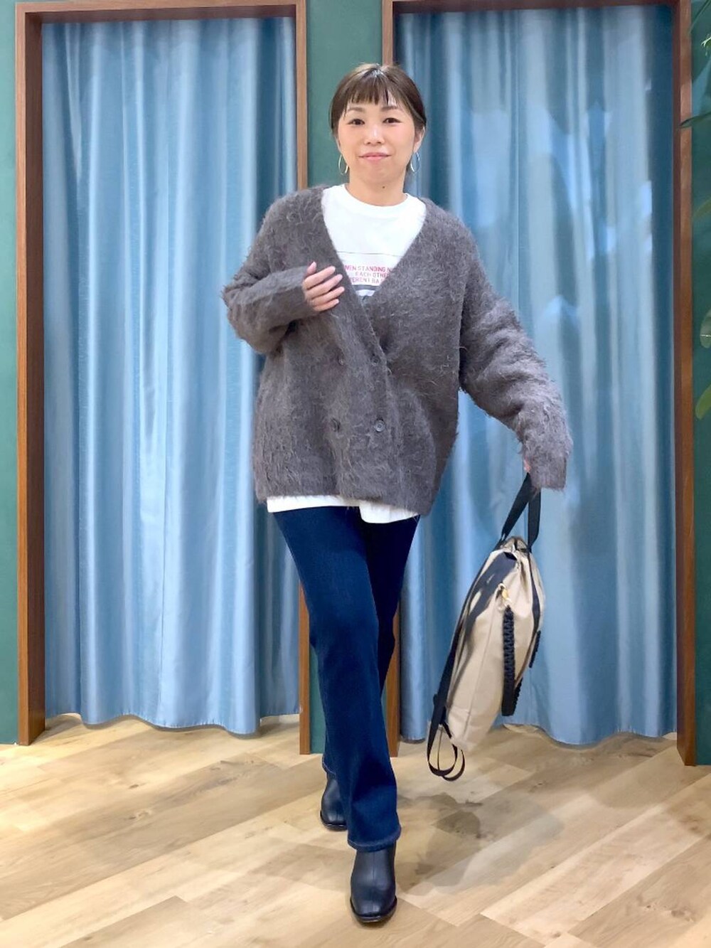 ブルー系のデニムパンツ、ブラック系のブーツ、ホワイト系のTシャツ/カットソーを着用したレディースの秋コーディネートの7枚目の写真