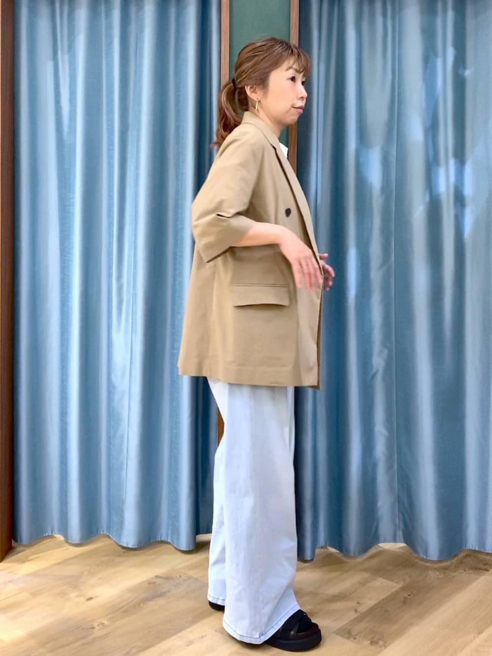 ブルー系のデニムパンツ、ホワイト系のTシャツ/カットソー、ブラウン系のサンダルを着用したレディースの春コーディネートの5枚目の写真