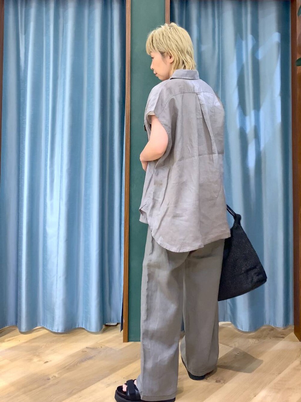 グレー系のその他パンツ、ホワイト系のTシャツ/カットソー、ブラック系のサンダルを着用したレディースの夏コーディネートの4枚目の写真