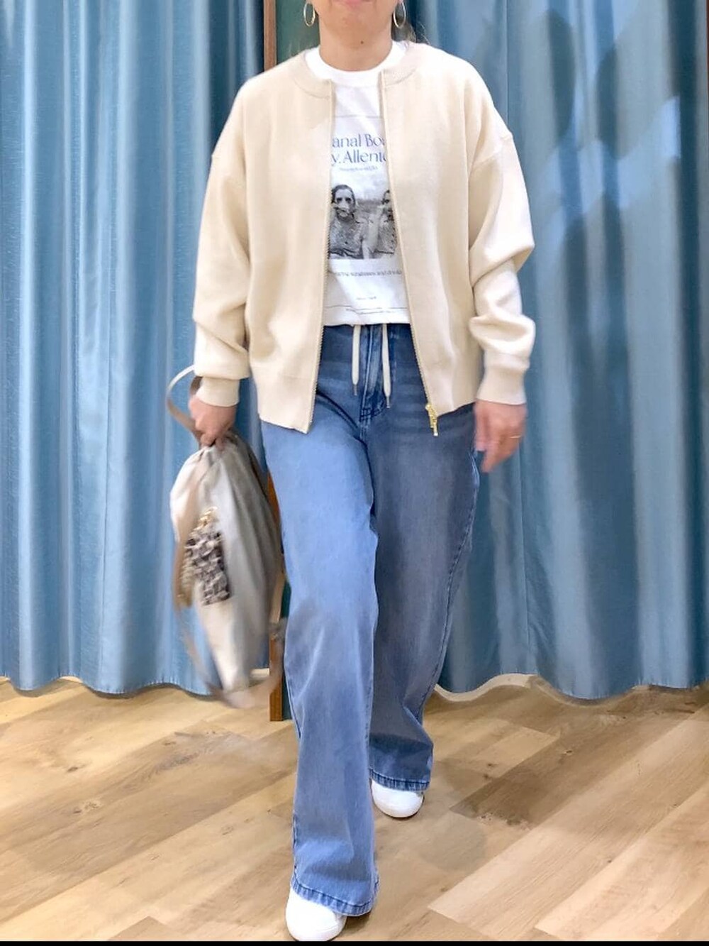 ホワイト系のカーディガン/ボレロ、ブルー系のデニムパンツ、ホワイト系のTシャツ/カットソーを着用したレディースの冬コーディネートの7枚目の写真