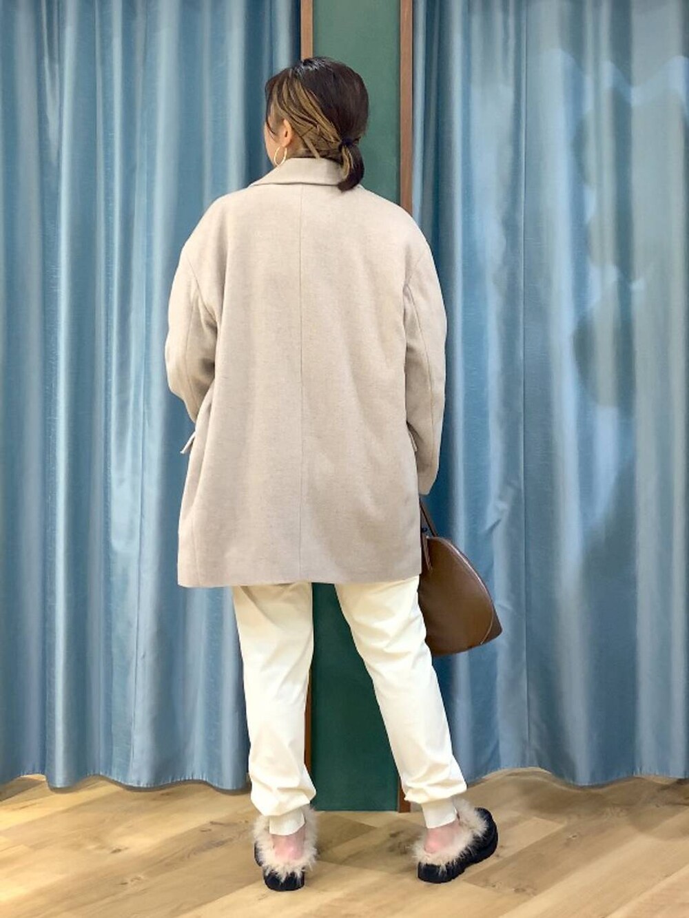 ブラウン系のトートバッグ、ブラウン系のニット/セーター、ベージュ系のピーコートを着用したレディースの秋コーディネートの4枚目の写真