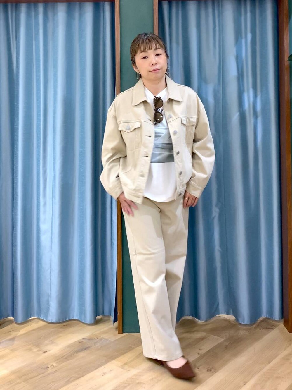 ブラウン系のパンプス、ベージュ系のデニムパンツ、ベージュ系のデニムジャケットを着用したレディースの春コーディネートの3枚目の写真