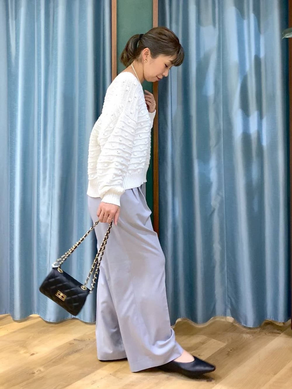 ホワイト系のニット/セーター、グレー系のその他パンツ、ブラック系のショルダーバッグを着用したレディースの冬コーディネートの3枚目の写真