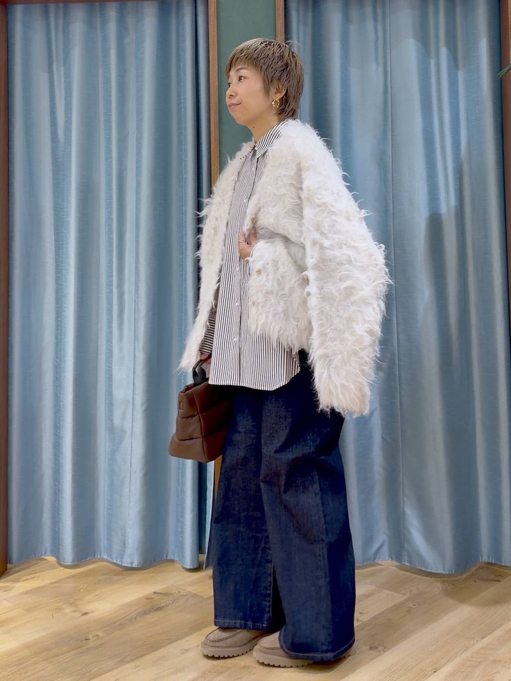 ベージュ系のシャツ/ブラウス、ブラウン系のトートバッグ、ブルー系のデニムパンツを着用したレディースの秋コーディネートの6枚目の写真