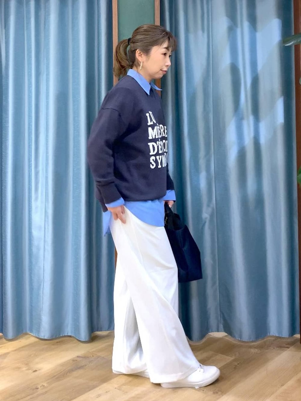 ホワイト系のスラックス、ブルー系のトートバッグ、グレー系のニット/セーターを着用したレディースの冬コーディネートの4枚目の写真