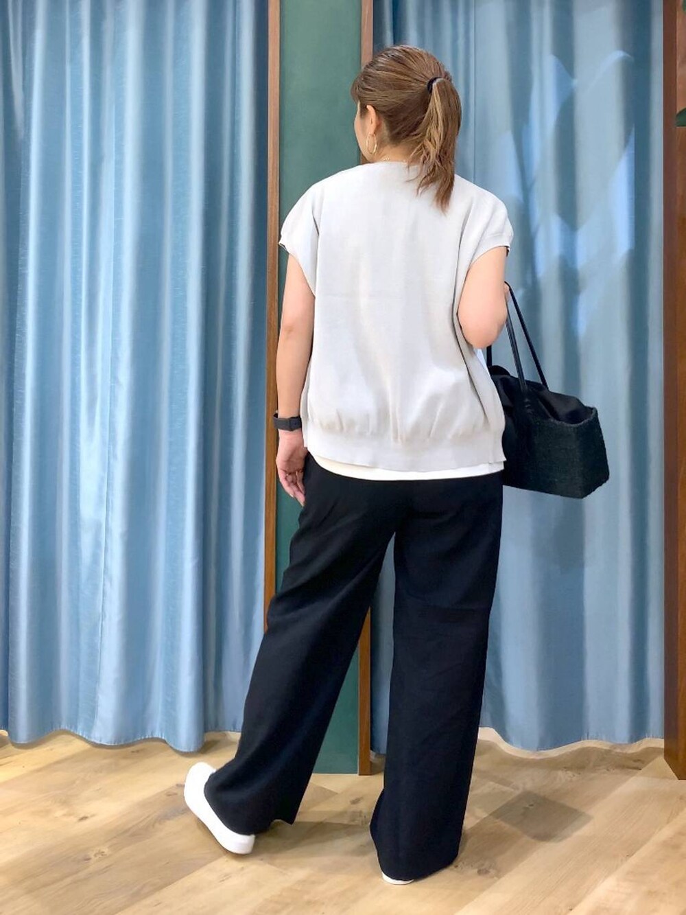 ホワイト系のTシャツ/カットソー、グレー系のニット/セーター、ブラック系のその他パンツを着用したレディースの春コーディネートの6枚目の写真