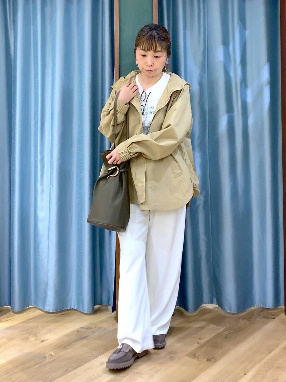 ホワイト系のその他パンツ、グレー系のローファー、ベージュ系のマウンテンパーカーを着用したレディースの春コーディネートの3枚目の写真