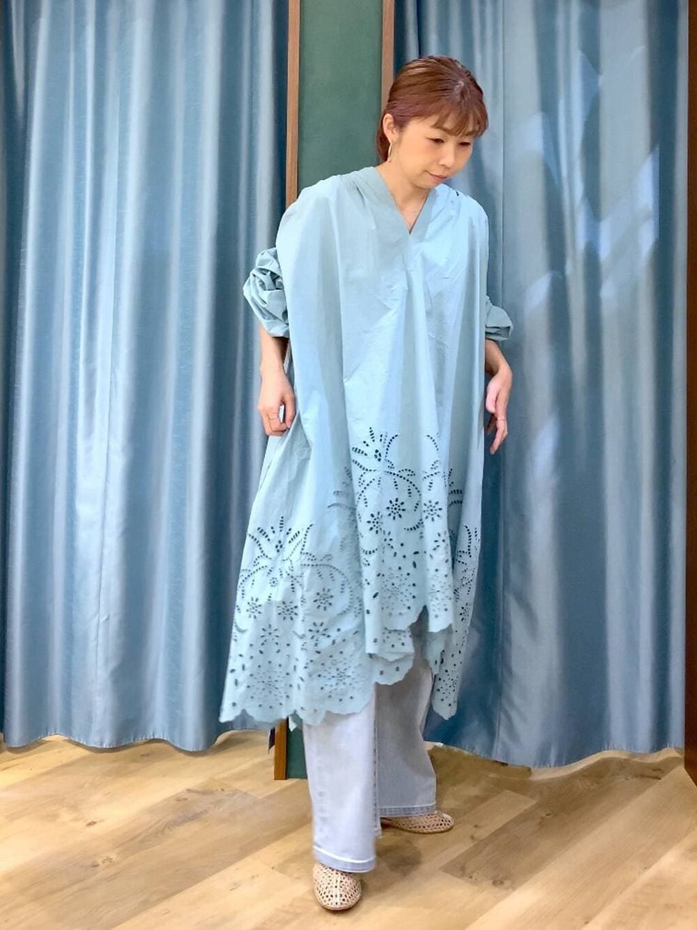 ブルー系のデニムパンツ、ベージュ系のスリッポン、グリーン系のワンピースを着用したレディースの春コーディネートの6枚目の写真