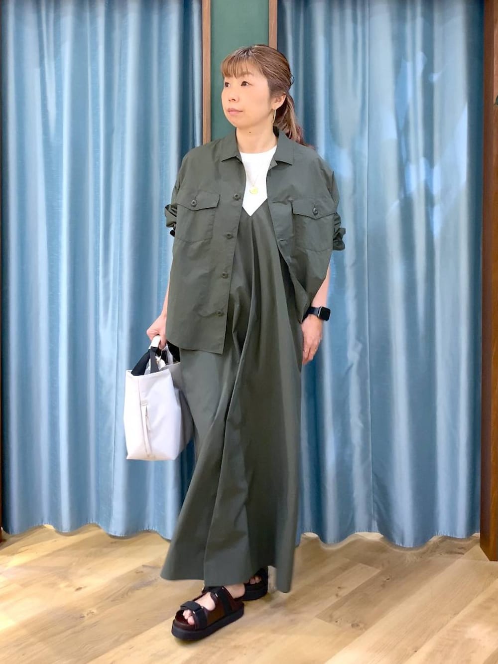 ホワイト系のトートバッグ、グリーン系のシャツ/ブラウス、ホワイト系のTシャツ/カットソーを着用したレディースの春コーディネートの2枚目の写真