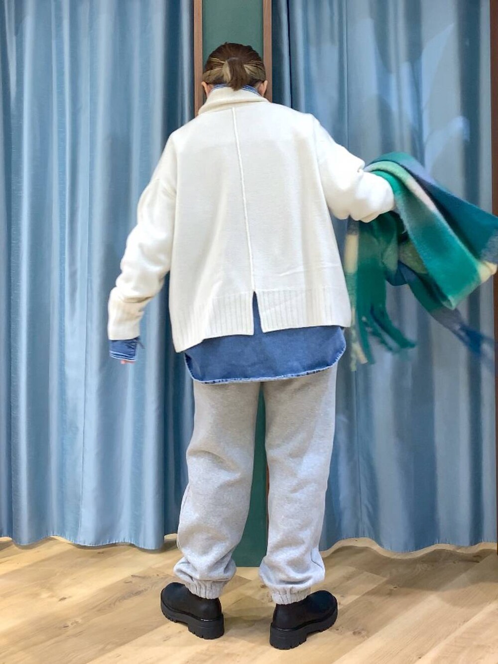 ブラック系のブーツ、ブルー系のシャツ/ブラウス、ホワイト系のニット/セーターを着用したレディースの秋コーディネートの5枚目の写真