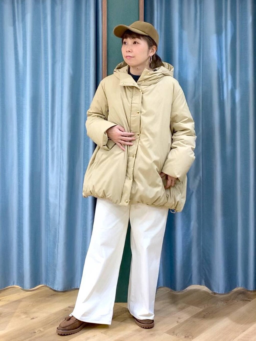 ベージュ系のダウンジャケット/コート、ブラウン系のローファー、グレー系のニット/セーターを着用したレディースの秋コーディネートの6枚目の写真