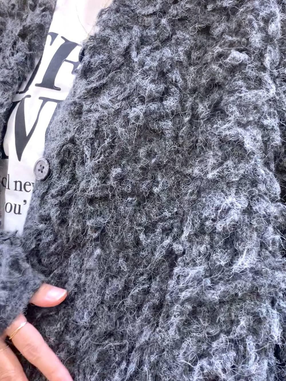 ブラック系のブーツ、ブラック系のスラックス、グレー系のカーディガン/ボレロを着用したレディースの冬コーディネートの7枚目の写真