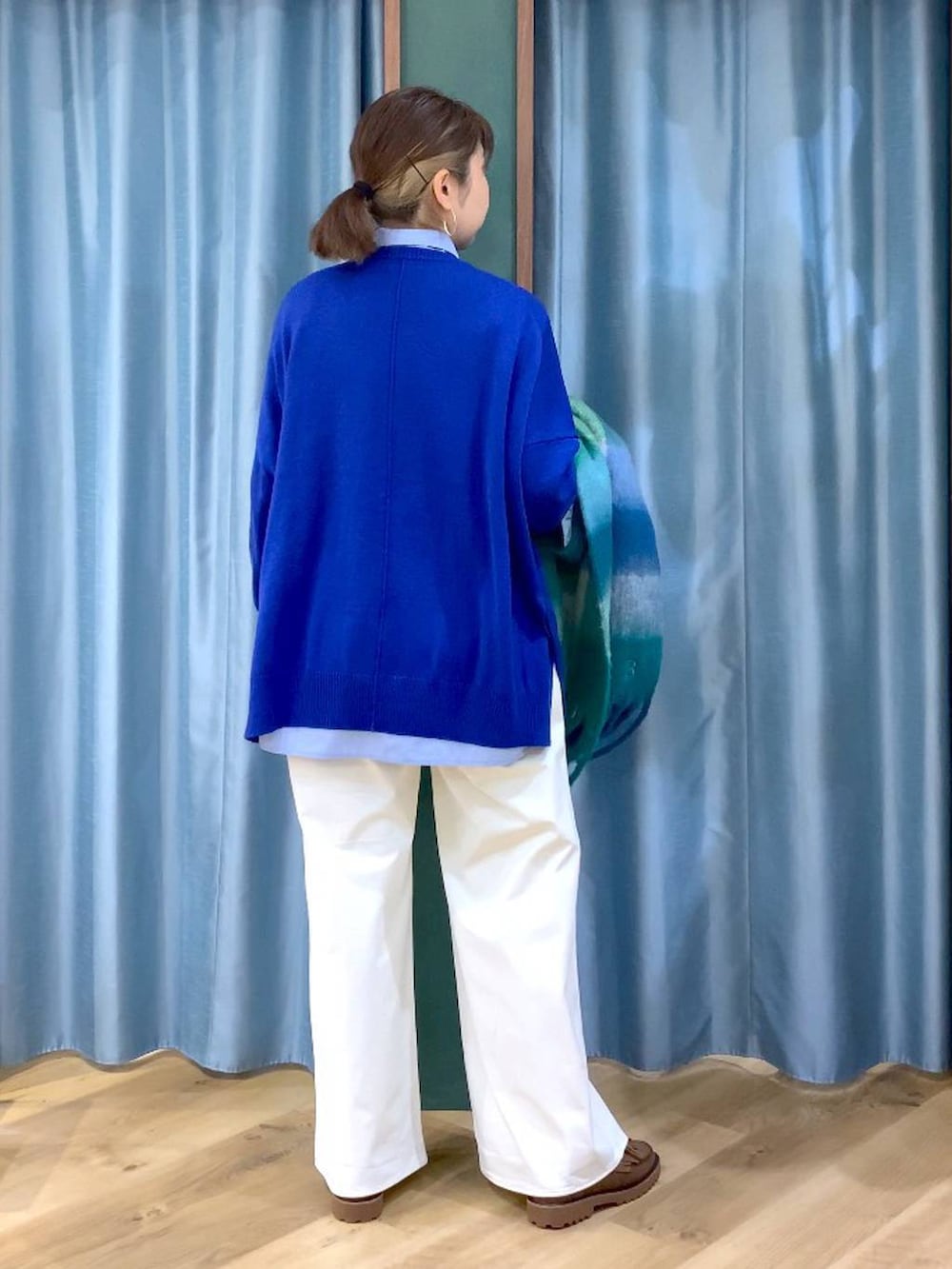 ブルー系のシャツ/ブラウス、ブラウン系のローファー、ブルー系のニット/セーターを着用したレディースの秋コーディネートの3枚目の写真