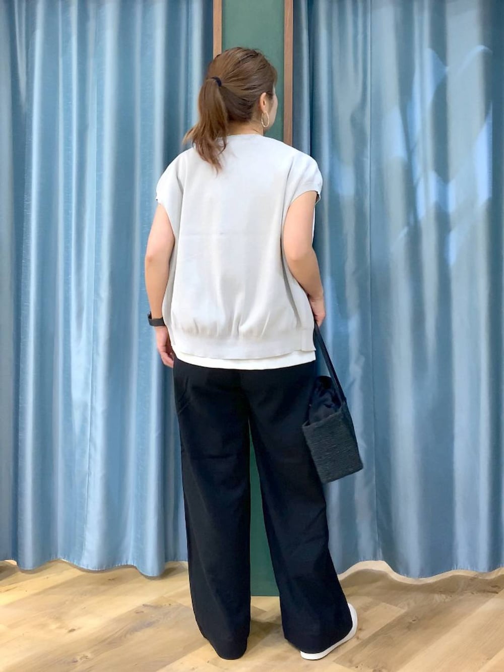 ホワイト系のTシャツ/カットソー、グレー系のニット/セーター、ブラック系のその他パンツを着用したレディースの春コーディネートの5枚目の写真
