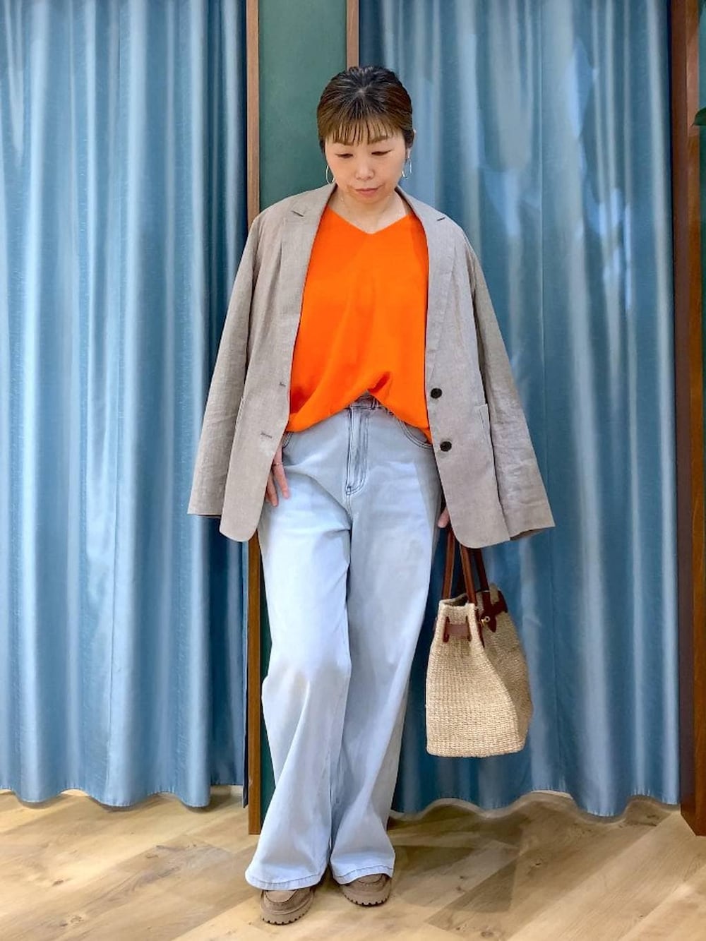 グレー系のローファー、ブルー系のデニムパンツ、ベージュ系のテーラードジャケットを着用したレディースの春コーディネートの3枚目の写真