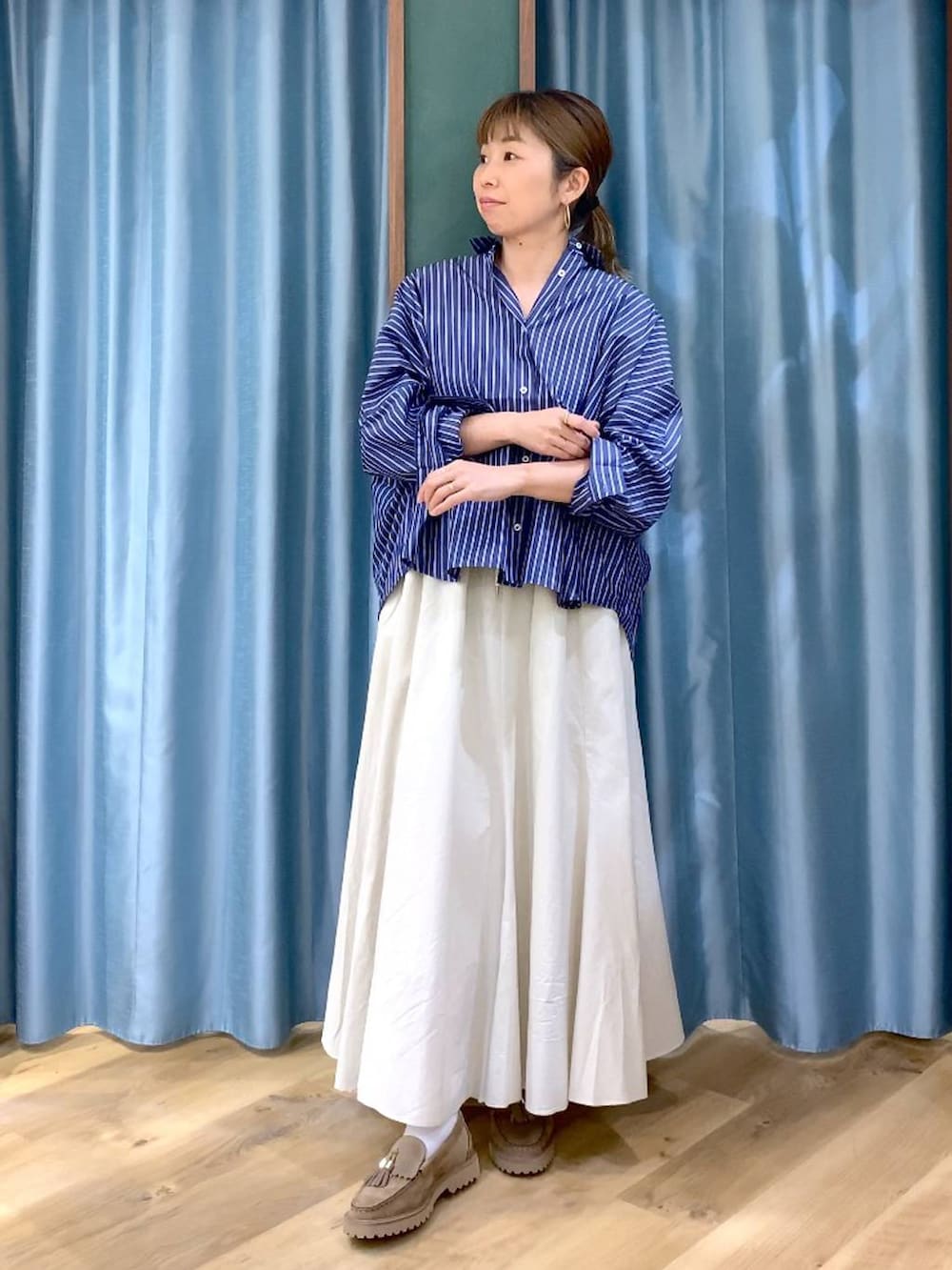 ベージュ系のローファー、ホワイト系のスカート、ブルー系のシャツ/ブラウスを着用したレディースの春コーディネートの3枚目の写真