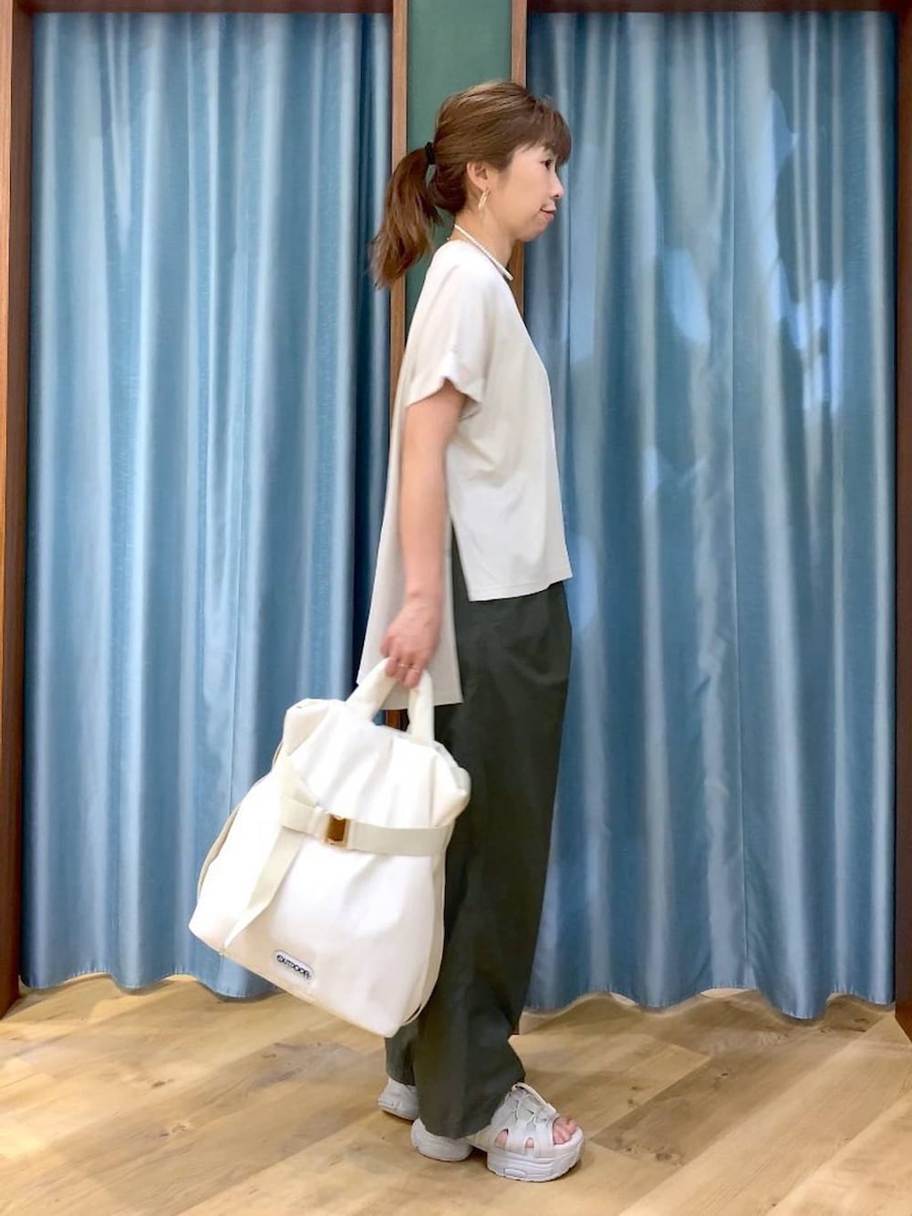 グリーン系のその他パンツ、ホワイト系のトートバッグ、グレー系のサンダルを着用したレディースの春コーディネートの2枚目の写真