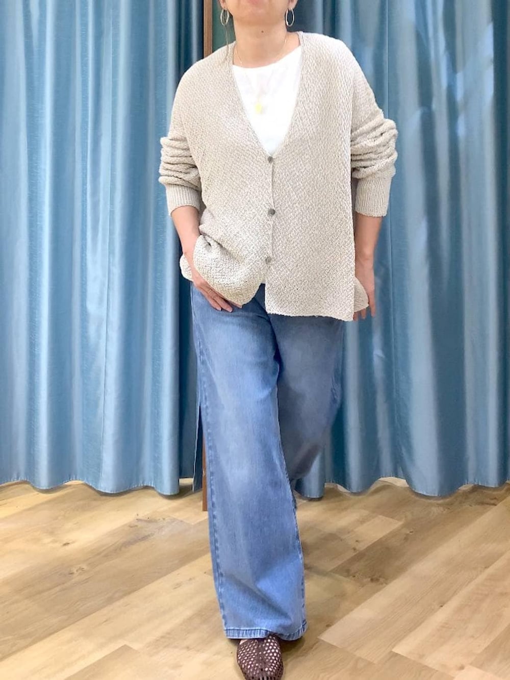 ブルー系のデニムパンツ、ホワイト系のTシャツ/カットソー、ベージュ系のカーディガン/ボレロを着用したレディースの春コーディネートの6枚目の写真