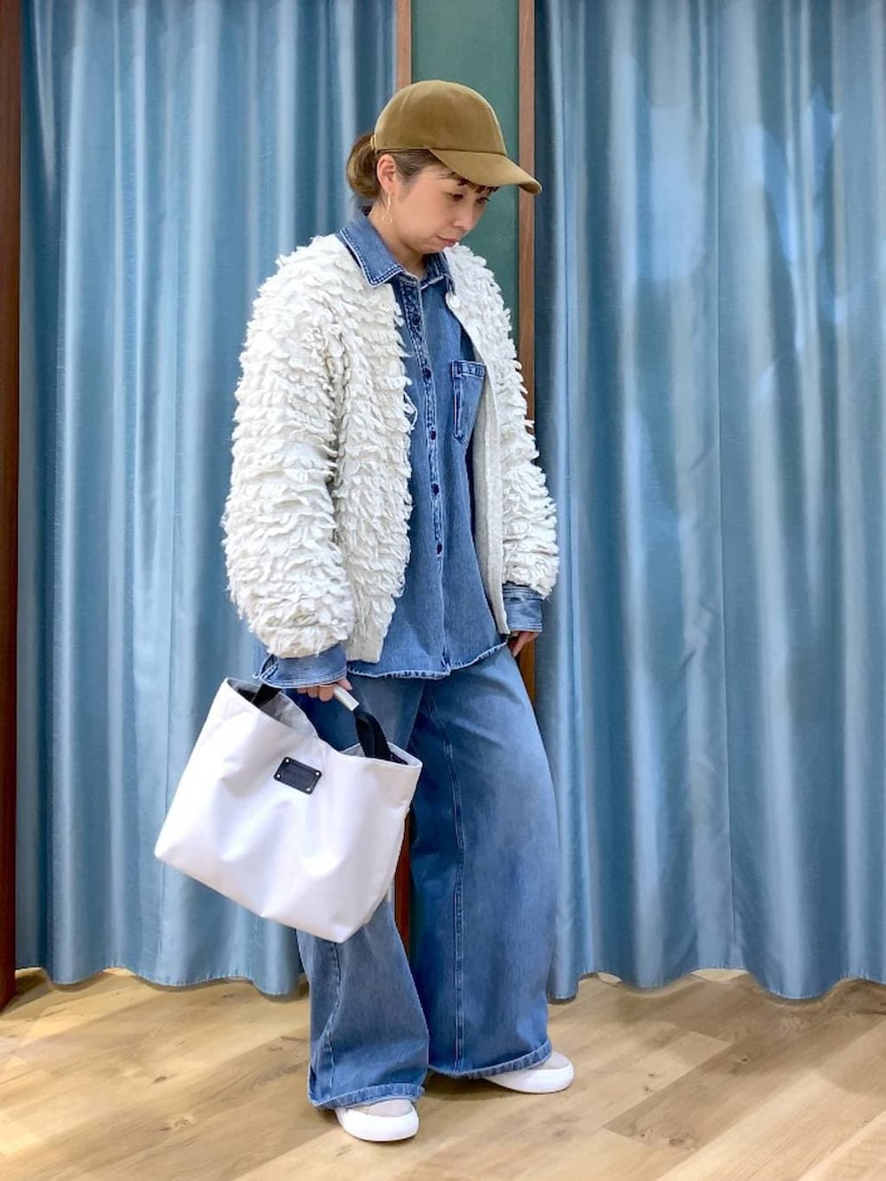 ブルー系のシャツ/ブラウス、ブルー系のデニムパンツ、ベージュ系のスニーカーを着用したレディースの冬コーディネートの2枚目の写真