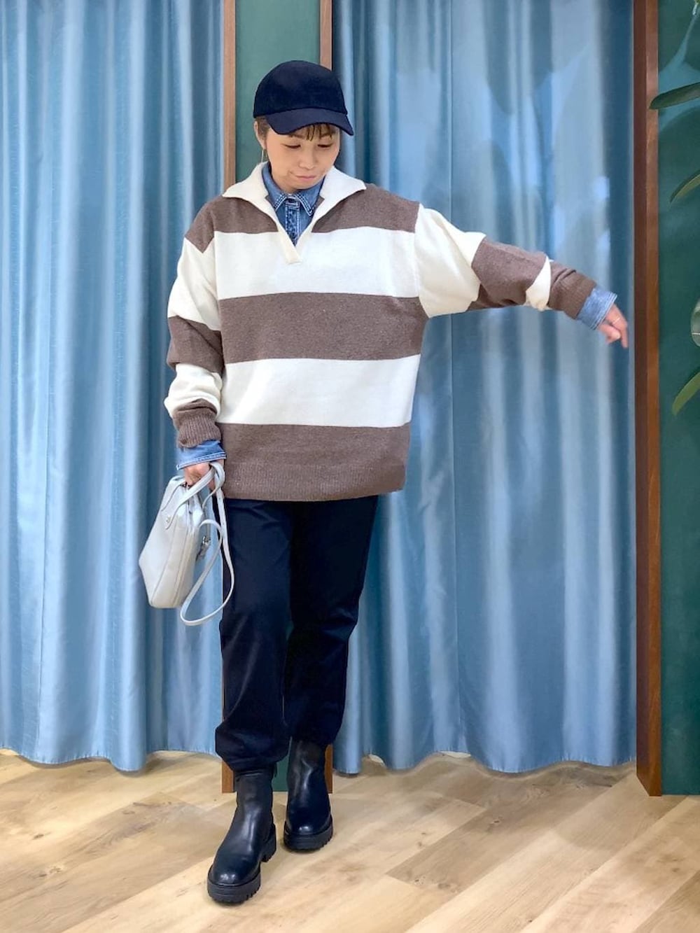 ブラック系のブーツ、ホワイト系のニット/セーター、ブルー系のシャツ/ブラウスを着用したレディースの冬コーディネートの6枚目の写真