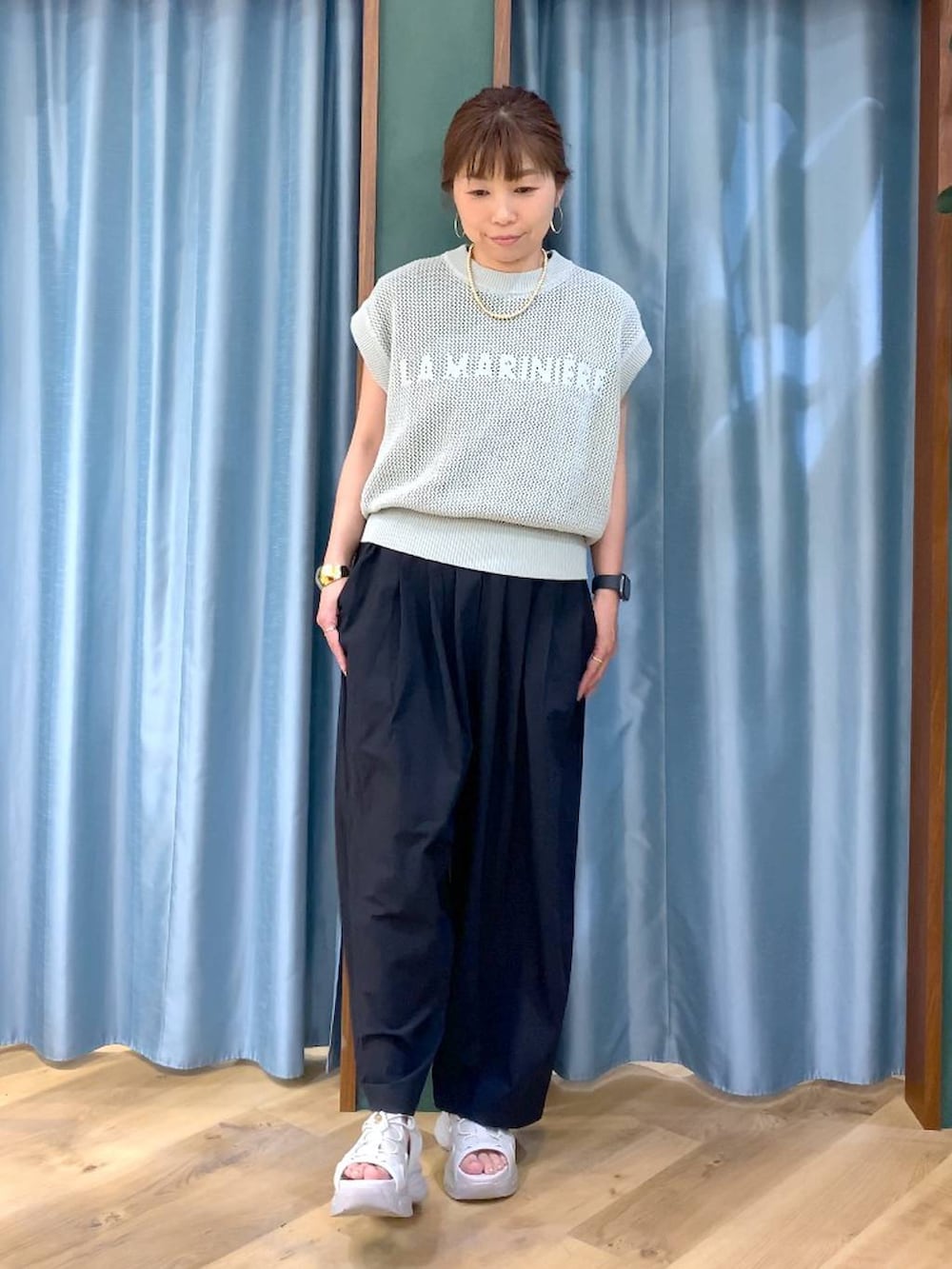 ブラック系のTシャツ/カットソー、グリーン系のニット/セーター、ブラック系のその他パンツを着用したレディースの春コーディネートの2枚目の写真