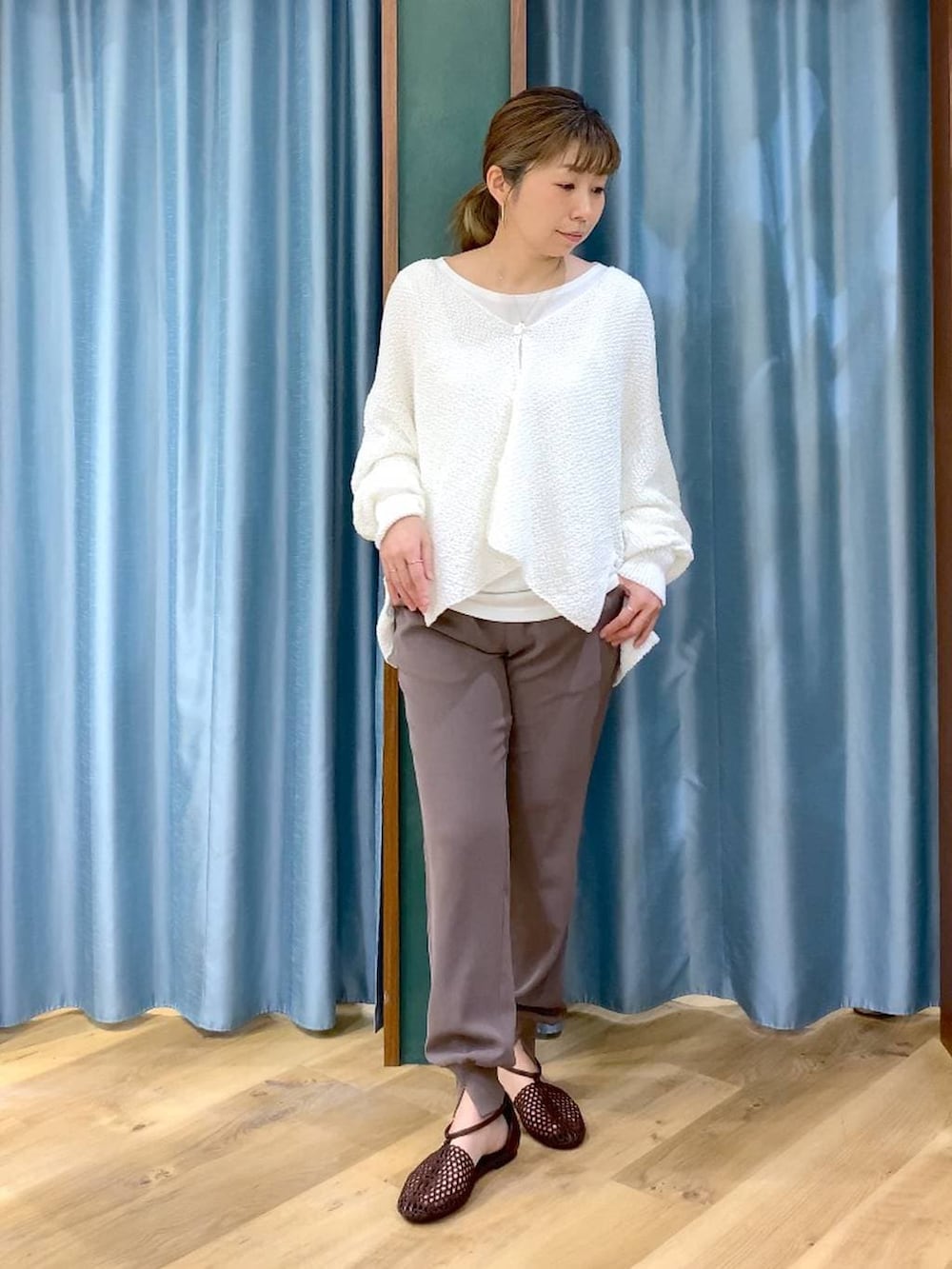 ホワイト系のTシャツ/カットソー、ホワイト系のカーディガン/ボレロ、ブラウン系のスリッポンを着用したレディースの春コーディネートの4枚目の写真
