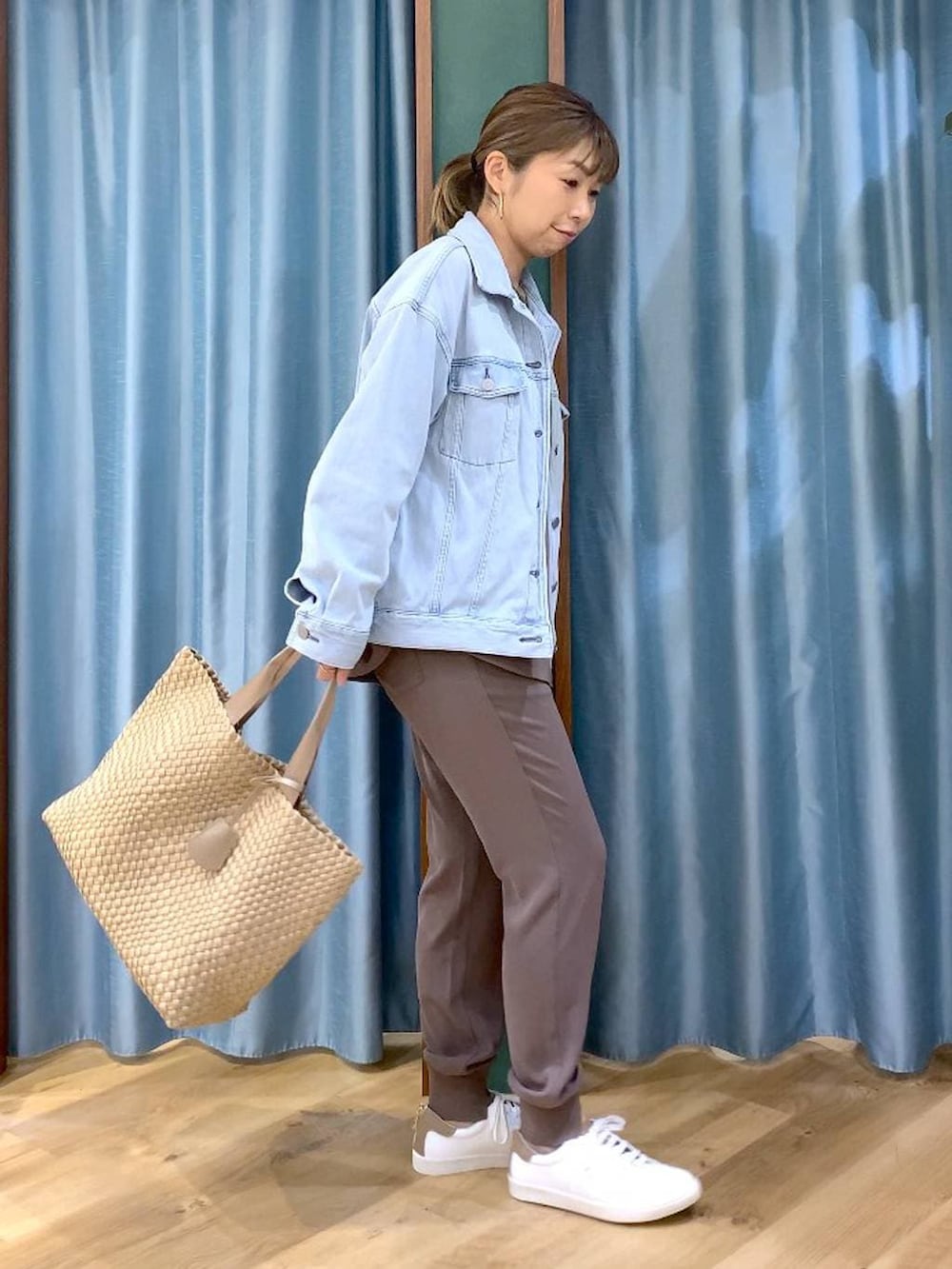 ブルー系のデニムジャケット、グリーン系のTシャツ/カットソー、ベージュ系のトートバッグを着用したレディースの冬コーディネートの6枚目の写真