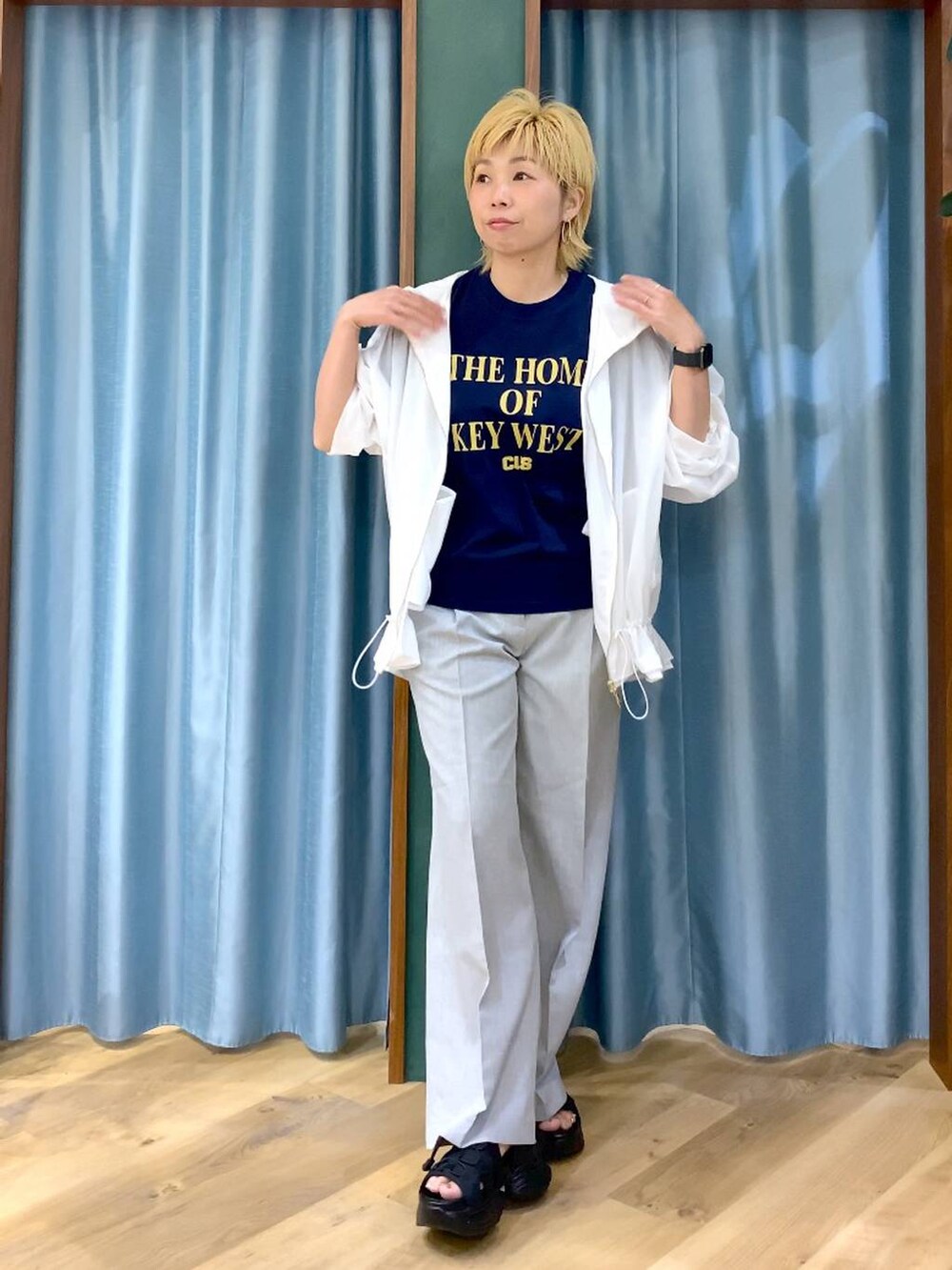 ブルー系のTシャツ/カットソー、ブラック系のサンダル、ホワイト系のブルゾンを着用したレディースの夏コーディネートの2枚目の写真