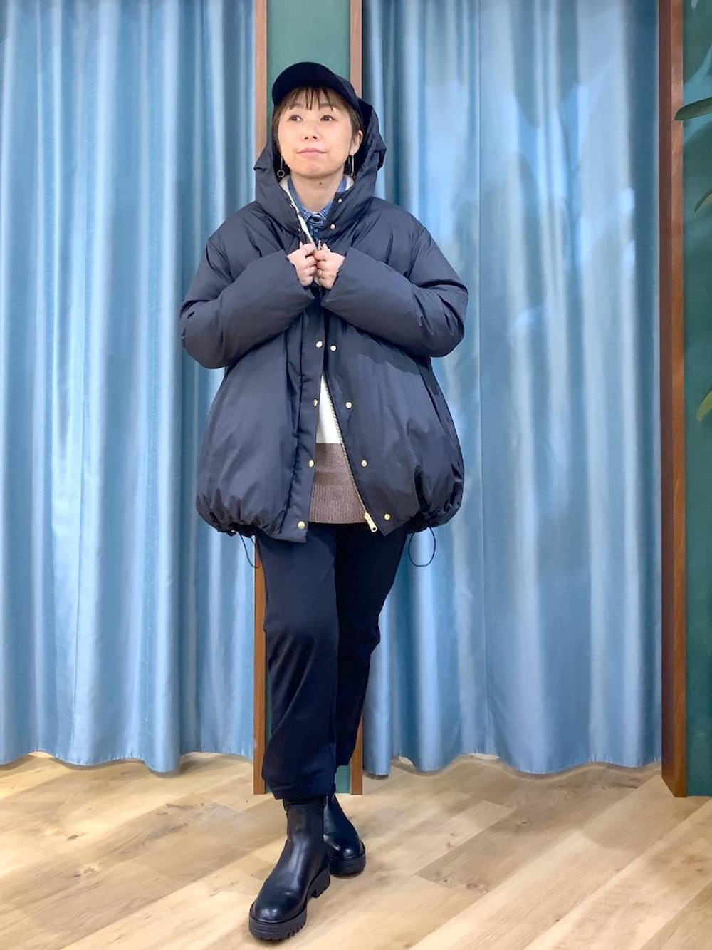 ブラック系のブーツ、ホワイト系のニット/セーター、ブルー系のシャツ/ブラウスを着用したレディースの冬コーディネートの7枚目の写真