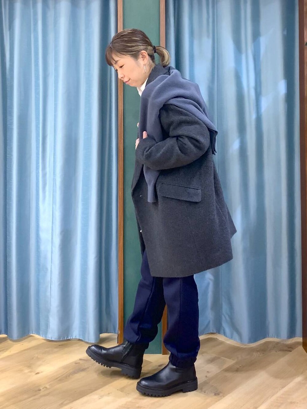 ブラック系のブーツ、ホワイト系のシャツ/ブラウス、グレー系のニット/セーターを着用したレディースの秋コーディネートの2枚目の写真