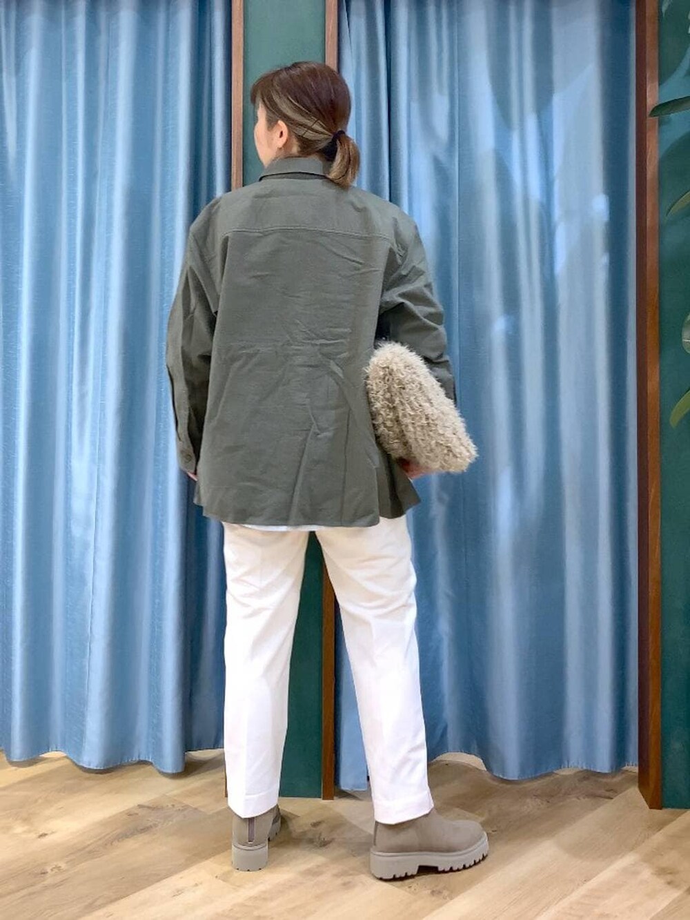 ベージュ系のハンドバッグ、ベージュ系のブーツ、ホワイト系のTシャツ/カットソーを着用したレディースの冬コーディネートの5枚目の写真