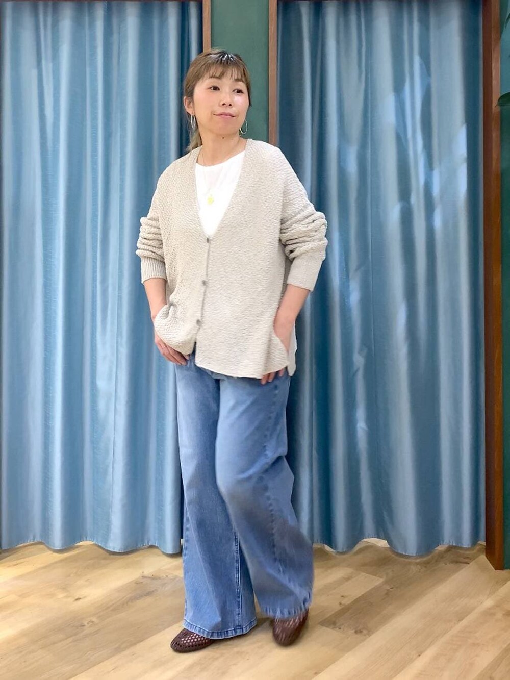 ブルー系のデニムパンツ、ホワイト系のTシャツ/カットソー、ベージュ系のカーディガン/ボレロを着用したレディースの春コーディネートの5枚目の写真