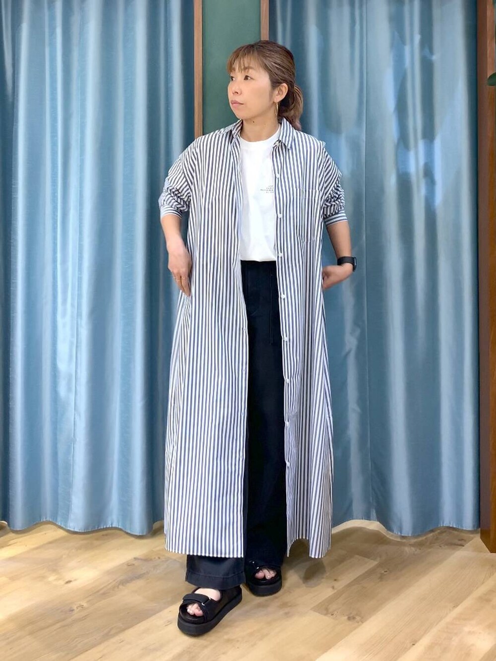 ホワイト系のTシャツ/カットソー、ブルー系のワンピース、グレー系のデニムパンツを着用したレディースの春コーディネートの4枚目の写真