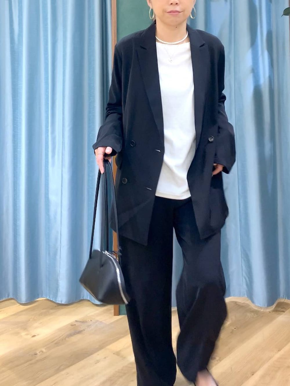 ブラック系のスラックス、ホワイト系のTシャツ/カットソー、ブラック系のテーラードジャケットを着用したレディースの冬コーディネートの9枚目の写真