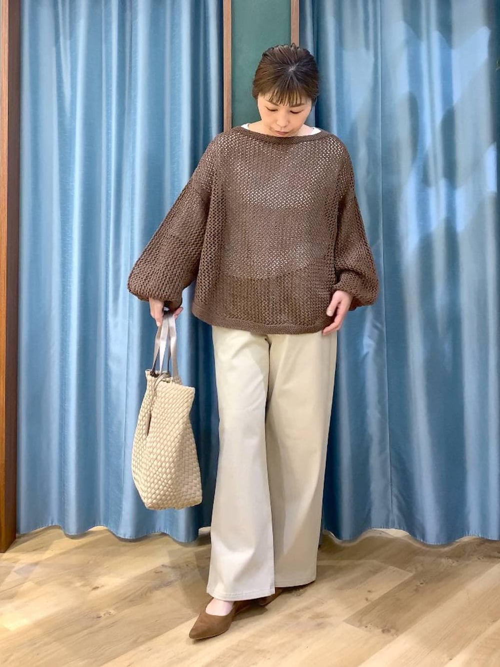 ブラウン系のニット/セーター、ホワイト系のTシャツ/カットソー、ベージュ系のデニムパンツを着用したレディースの冬コーディネートの3枚目の写真