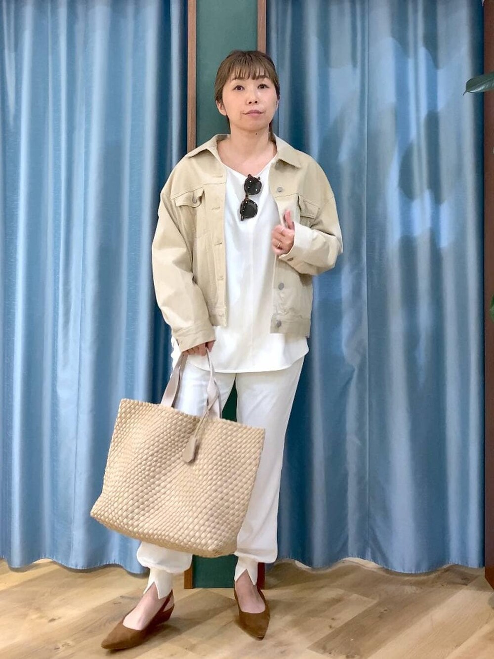 ベージュ系のデニムジャケット、ホワイト系のTシャツ/カットソー、ベージュ系のトートバッグを着用したレディースの冬コーディネートの2枚目の写真