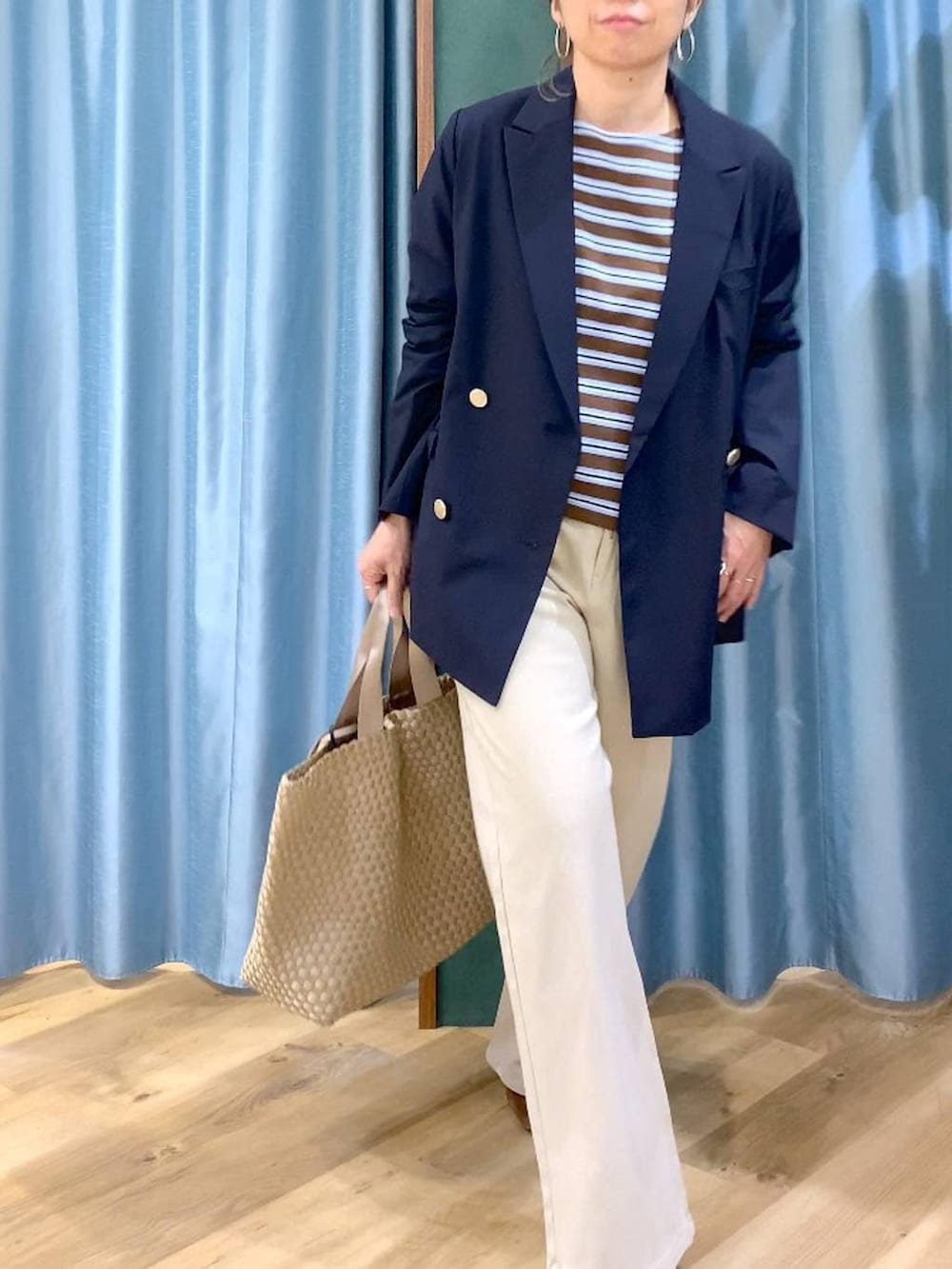 ブラウン系のTシャツ/カットソー、ベージュ系のデニムパンツ、ブルー系のテーラードジャケットを着用したレディースの冬コーディネートの7枚目の写真