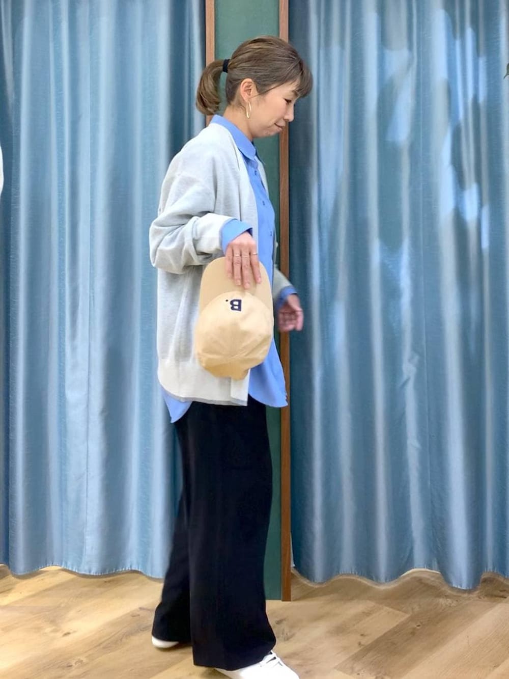 ブラック系のスラックス、ホワイト系のカーディガン/ボレロ、ブルー系のシャツ/ブラウスを着用したレディースの冬コーディネートの3枚目の写真