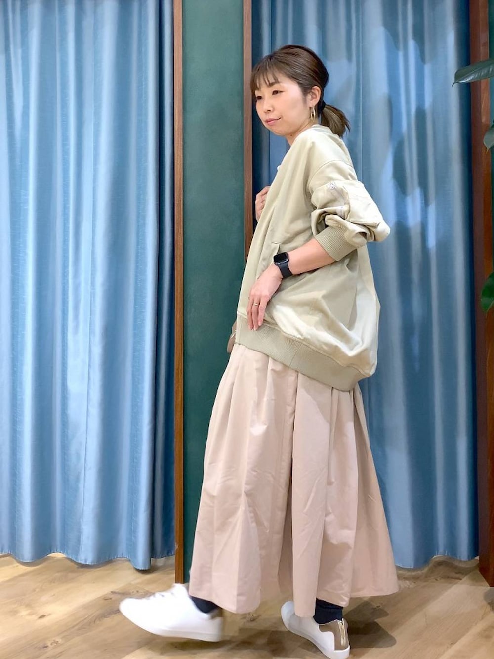 ブラウン系のショルダーバッグ、ベージュ系のスカート、ベージュ系のMA-1を着用したレディースの冬コーディネートの5枚目の写真