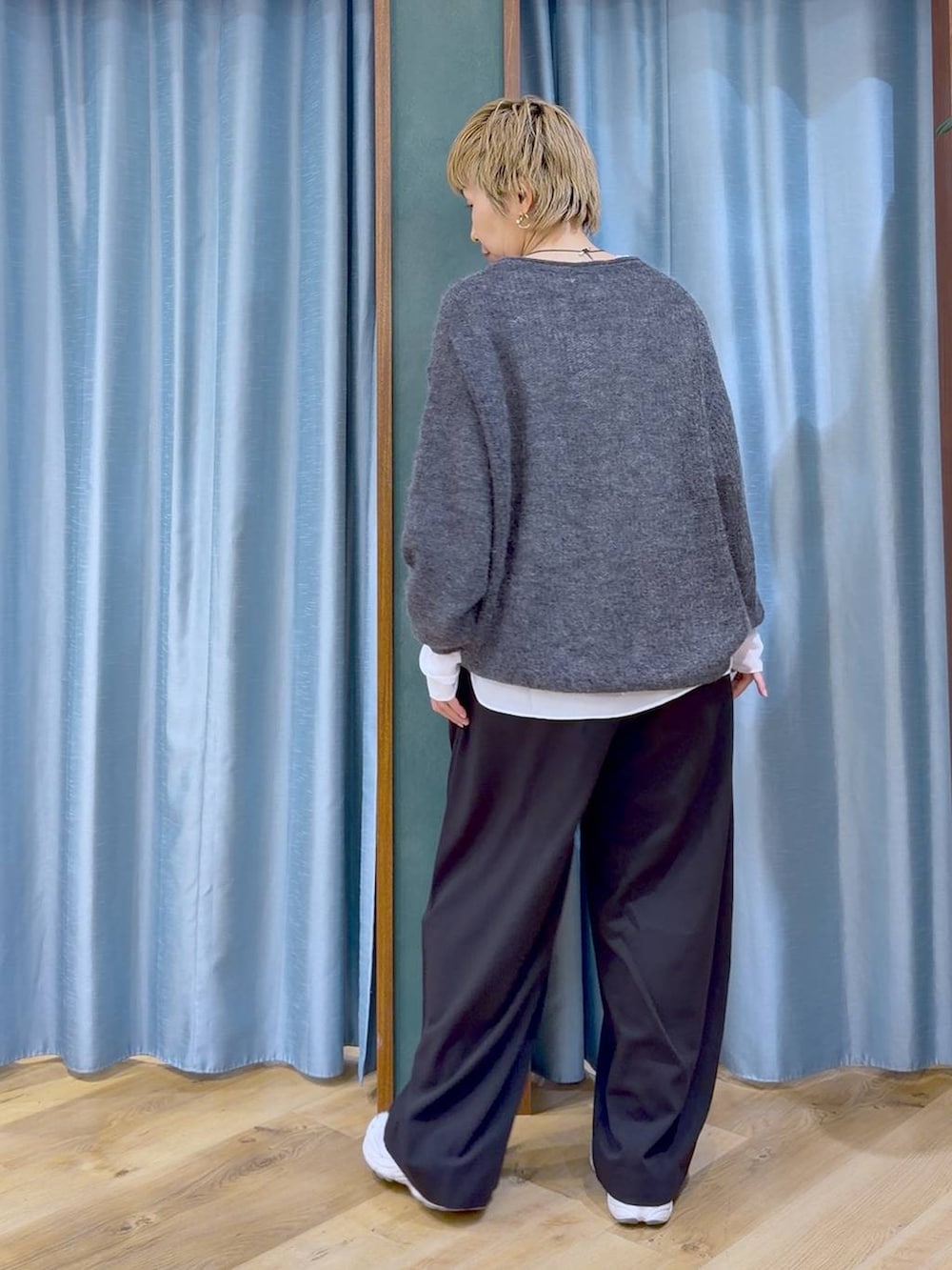 グレー系のニット/セーター、ブラック系のその他パンツ、ホワイト系のTシャツ/カットソーを着用したレディースの秋コーディネートの6枚目の写真