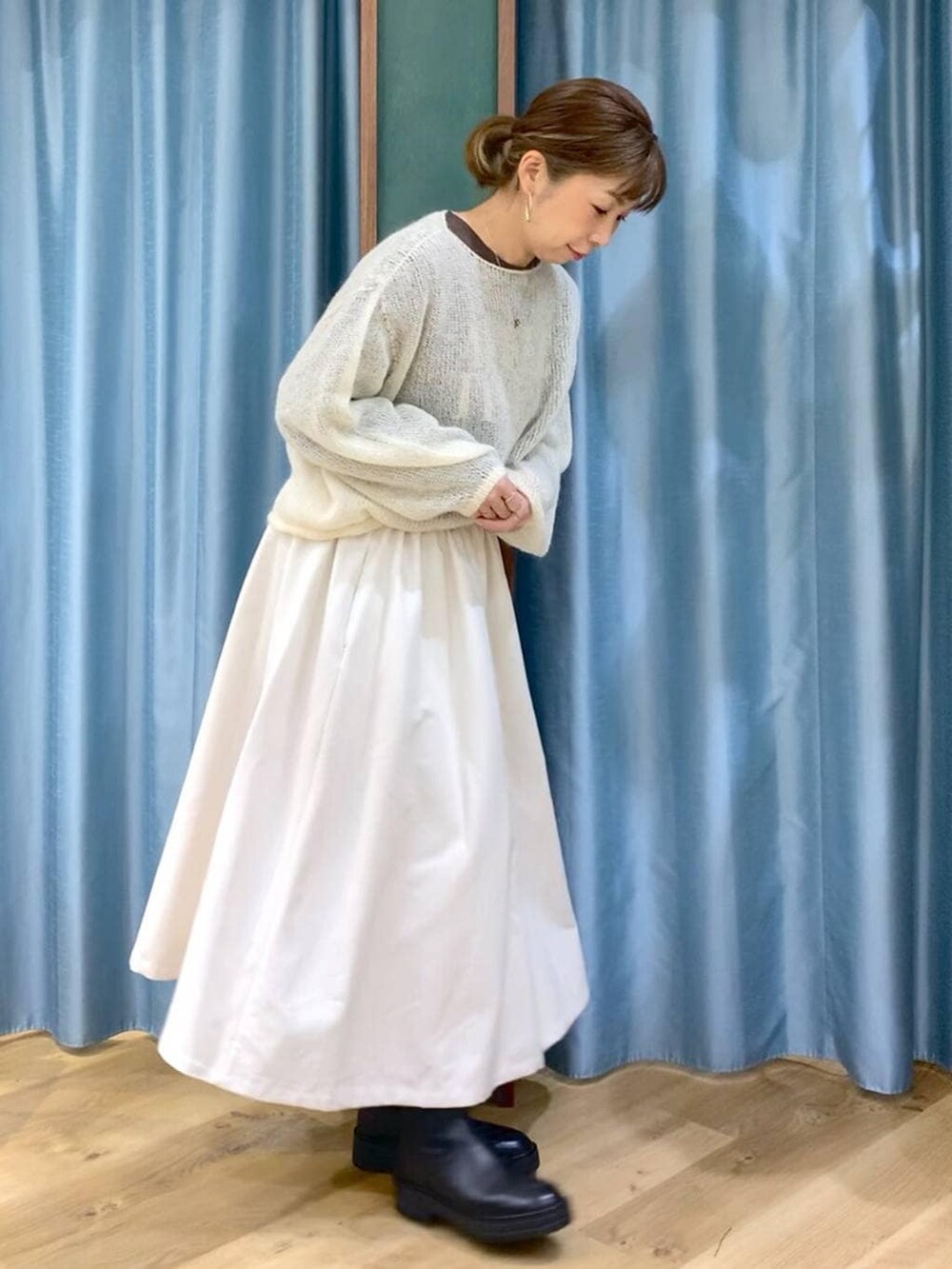 ブラック系のブーツ、ホワイト系のスカート、ホワイト系のニット/セーターを着用したレディースの冬コーディネートの5枚目の写真