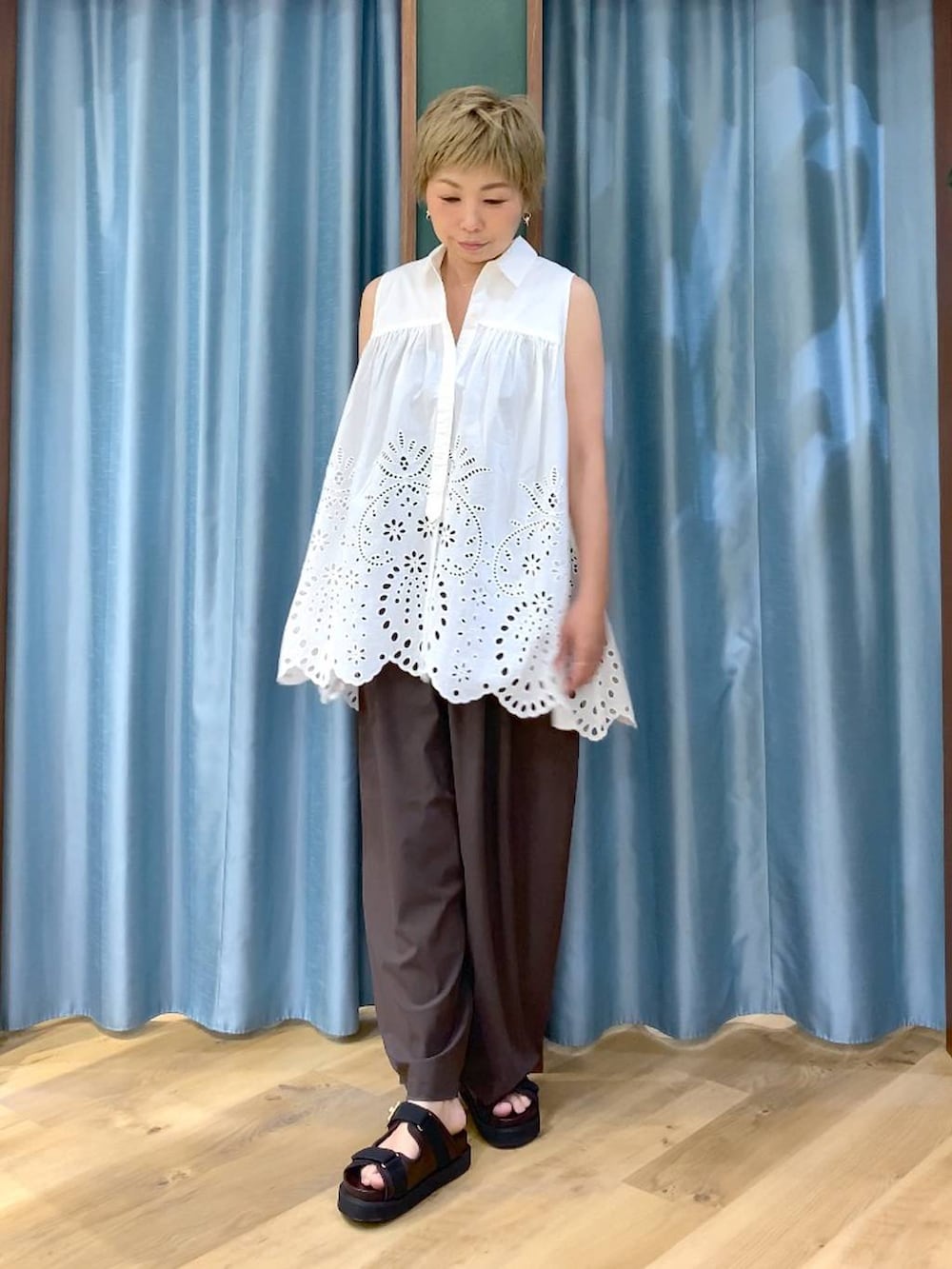 ブラウン系のその他パンツ、ホワイト系のシャツ/ブラウス、ブラウン系のサンダルを着用したレディースの夏コーディネートの3枚目の写真