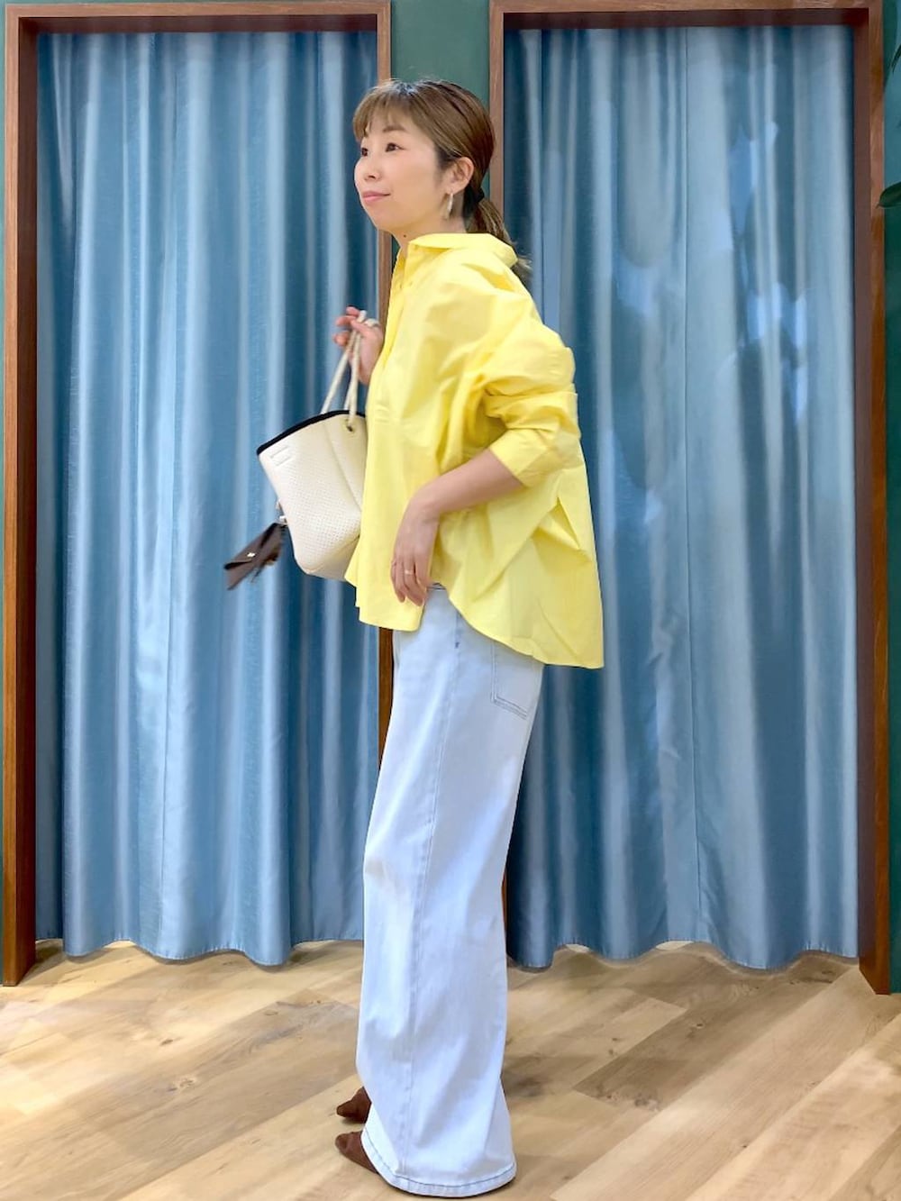 ブラウン系のパンプス、ブルー系のデニムパンツ、イエロー系のシャツ/ブラウスを着用したレディースの春コーディネートの5枚目の写真