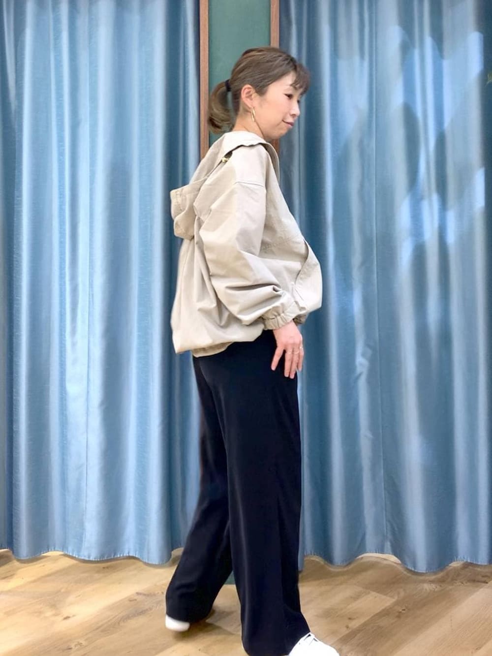 ブラック系のスラックス、ベージュ系のブルゾン、ホワイト系のTシャツ/カットソーを着用したレディースの冬コーディネートの3枚目の写真