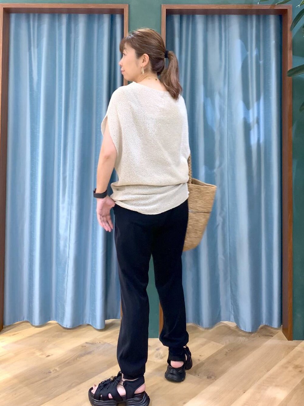 ブラック系のサンダル、ベージュ系のかごバッグ、ブラック系のその他パンツを着用したレディースの春コーディネートの4枚目の写真