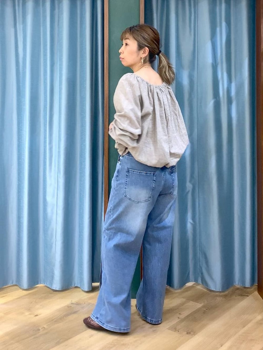 ブルー系のデニムパンツ、ベージュ系のシャツ/ブラウス、ブラウン系のスリッポンを着用したレディースの春コーディネートの6枚目の写真