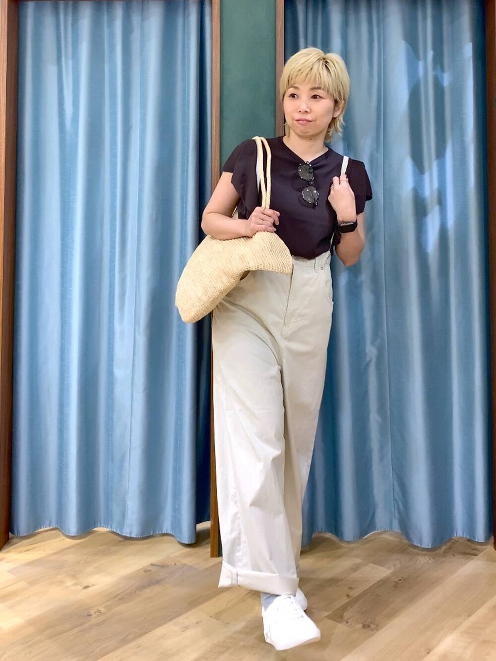 ベージュ系のその他パンツ、ブラウン系のニット/セーター、ベージュ系のかごバッグを着用したレディースの春コーディネートの4枚目の写真