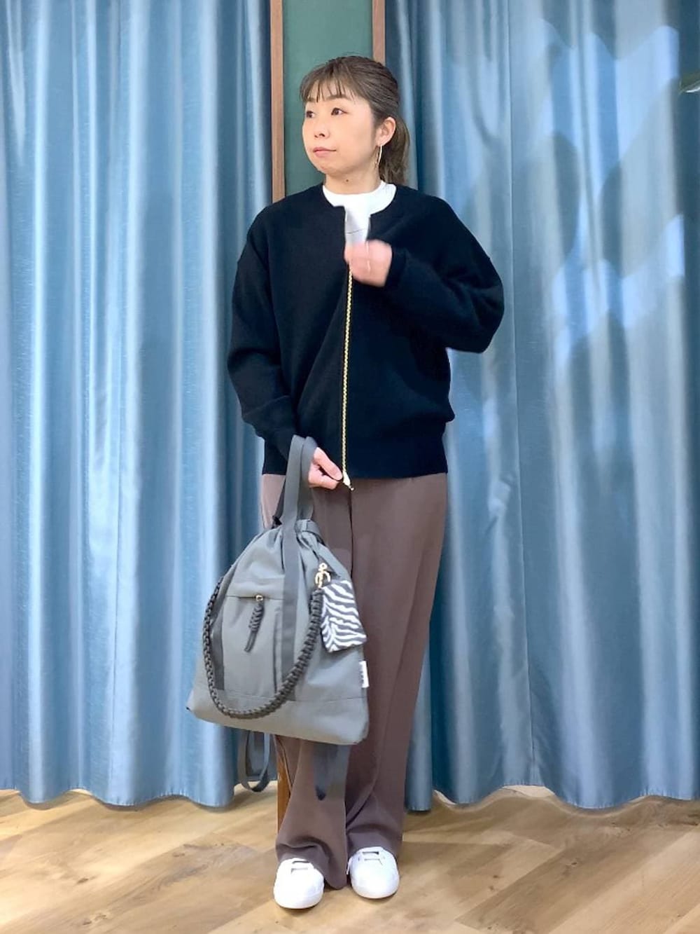 グリーン系のスラックス、ブラック系のカーディガン/ボレロ、グレー系のバックパック/リュックを着用したレディースの冬コーディネートの4枚目の写真